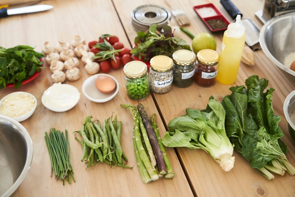 A vibrant and colorful spread of various raw and prepared plant-based ingredients like fresh vegetables tofu tempeh legu