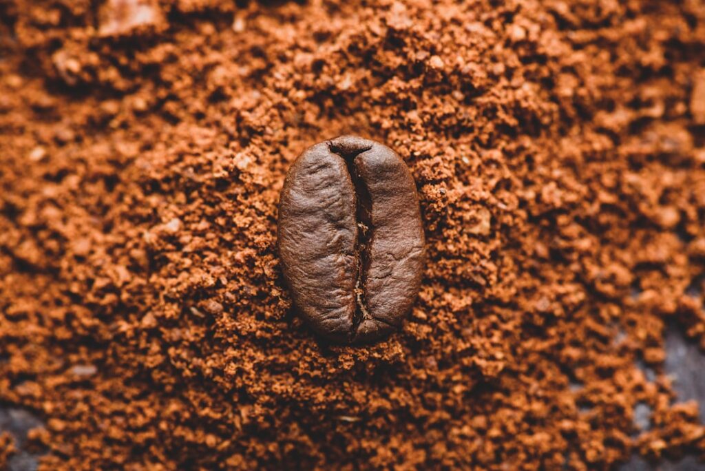 A close-up shot of finely ground coffee beans possibly in a small bowl or scattered on a wooden surface highlighting the