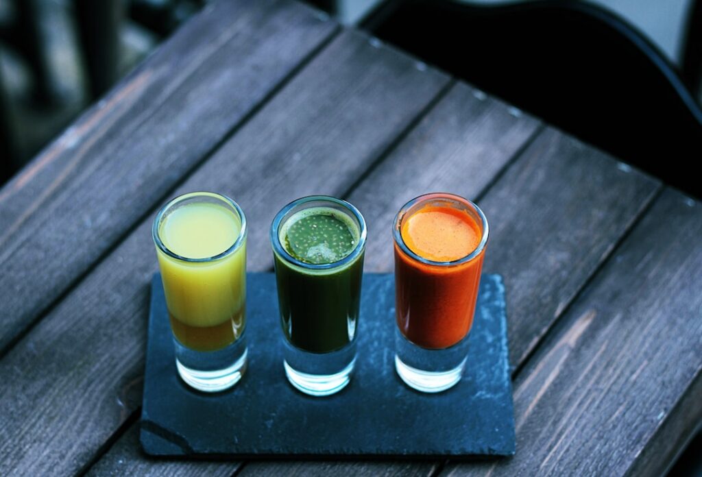 A variety of healthy drinks like green tea chia water lemon water and coconut water artfully arranged on a light backgro