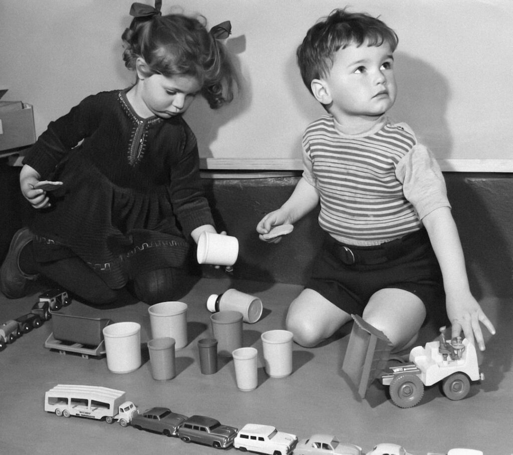A vintage scene of children playing outdoors in the 1960s perhaps with a classic pitcher and cups of a colorful beverage