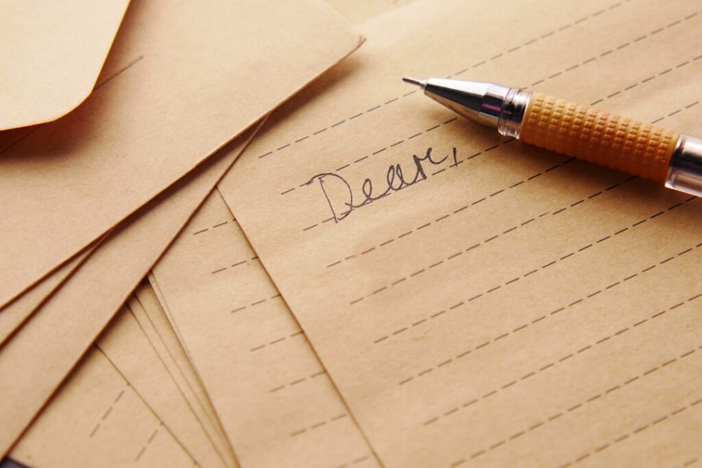 People writing letters or postcards in the 1980s evoking a sense of nostalgia for physical mail