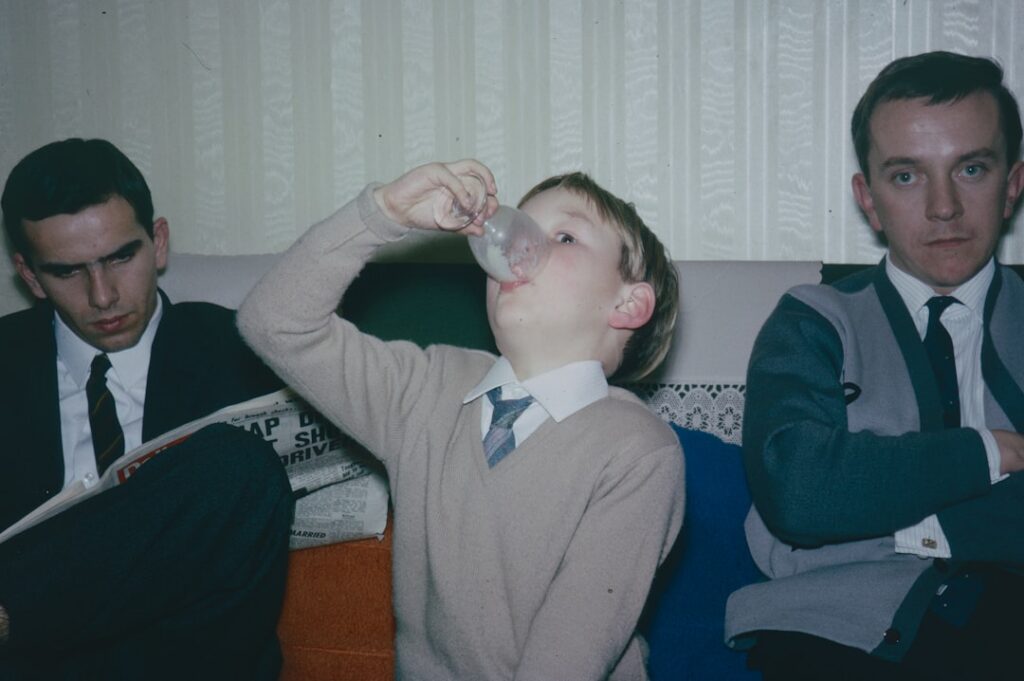 A vibrant retro-style illustration or photo of children from the 1960s enjoying a refreshing drink outdoors perhaps with