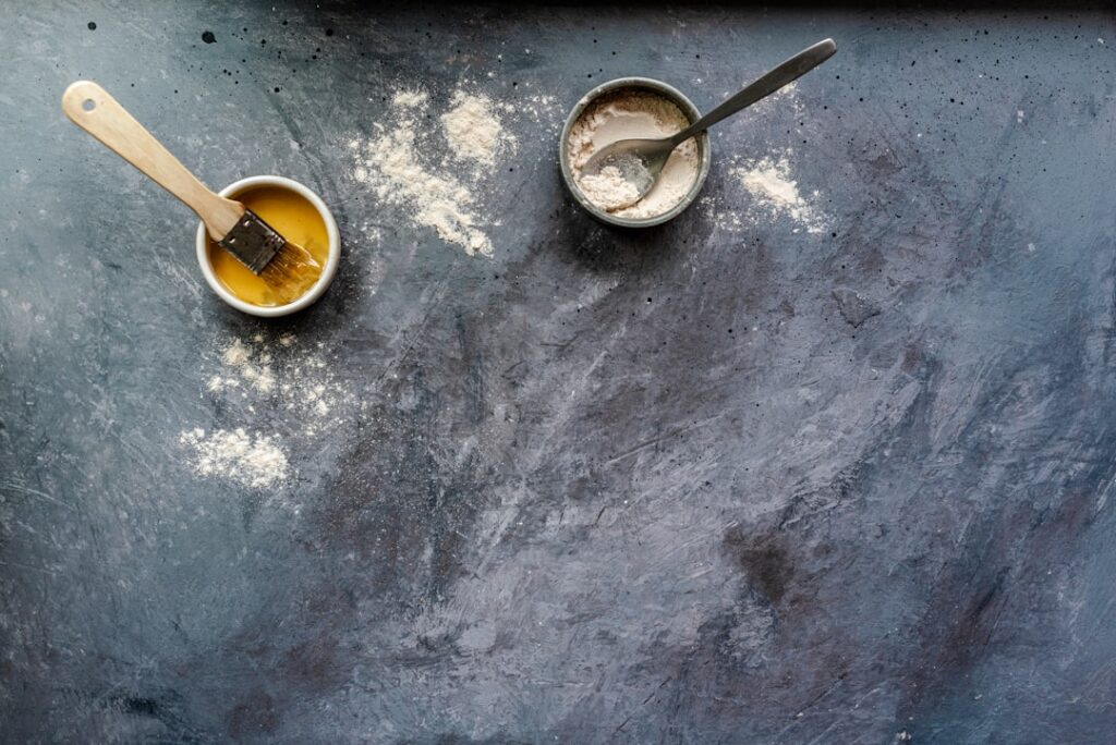 A close-up shot of a small bowl containing a creamy light brown DIY face mask made from ground rice and cloves Raw rice 