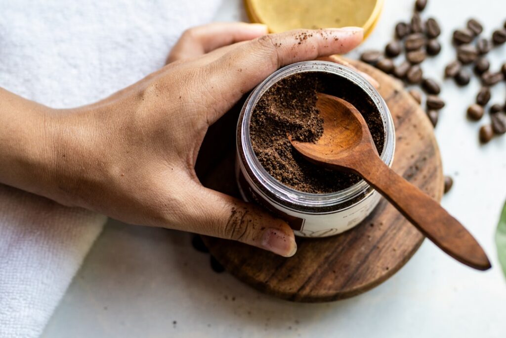 Close-up of a woman gently applying a coffee-based face mask to her cheek with natural ingredients like coffee grounds a
