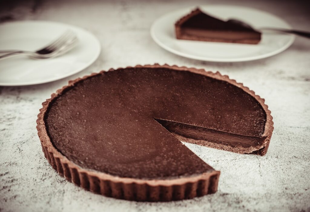 A beautifully plated slice of no-bake mocha tart showing layers of dark chocolate crust and light brown creamy mocha fil