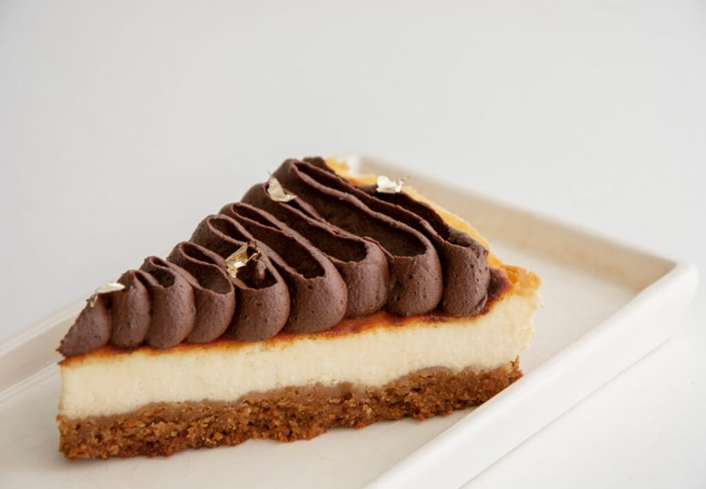 A beautifully plated slice of Vegan Coffee Petit Beurre Cake showing distinct layers of coffee-infused biscuits and crea