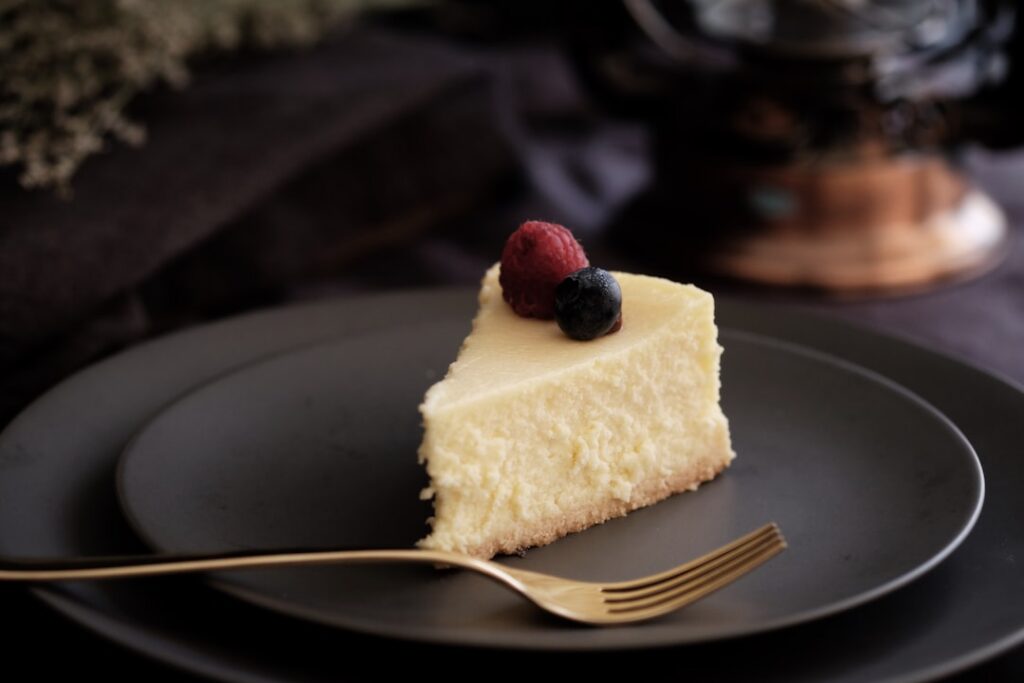 A perfectly baked fluffy light golden-brown vegan Japanese cheesecake on a clean light background perhaps with a few fre