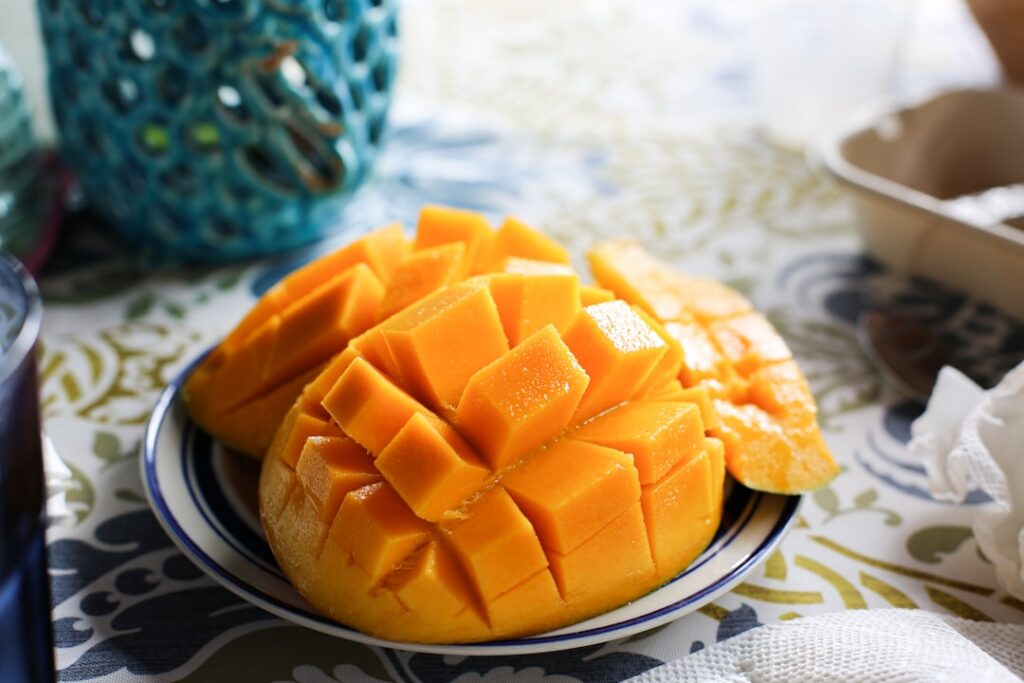 A vibrant flat lay showing fresh mango slices dried mango pieces and a smoothie with mango in a glass