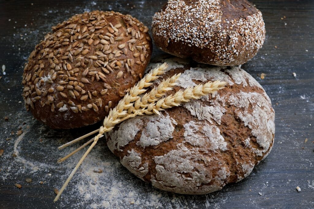 An array of different types of bread slices laid out including whole wheat rye sourdough and white bread to visually rep