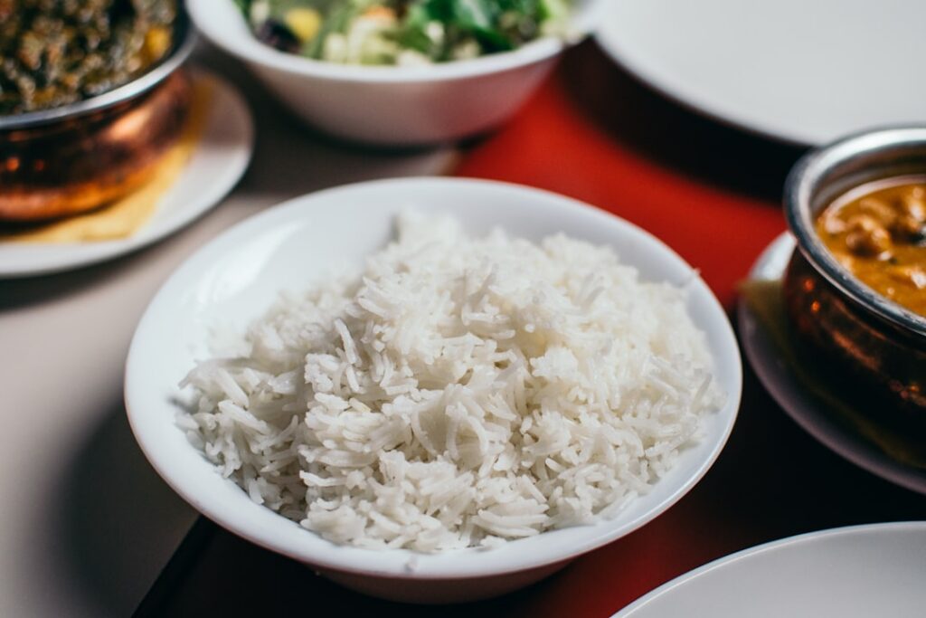 An infographic comparing the nutritional values of a cup of cooked white rice and a medium baked potato with icons and c