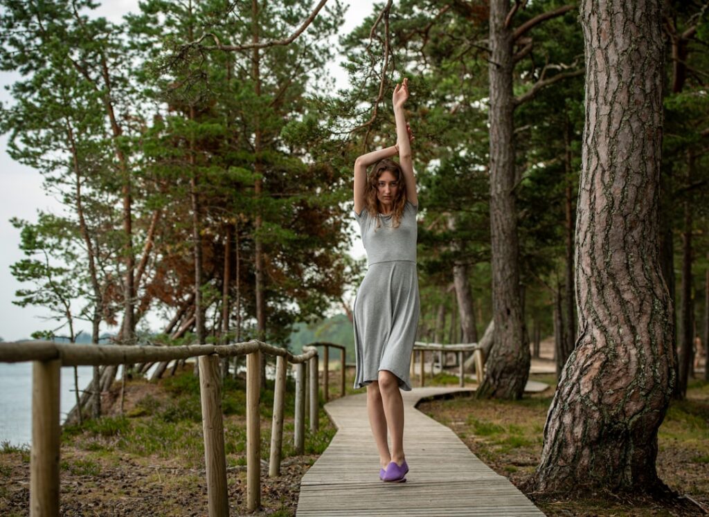 A person happily stretching or doing light exercise outdoors perhaps in a park or by a lake looking relaxed and joyful T