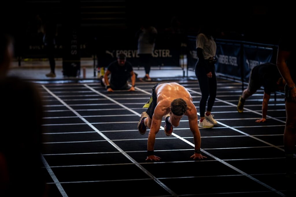 A person performing a modified burpee demonstrating stepping feet back and forth instead of jumping