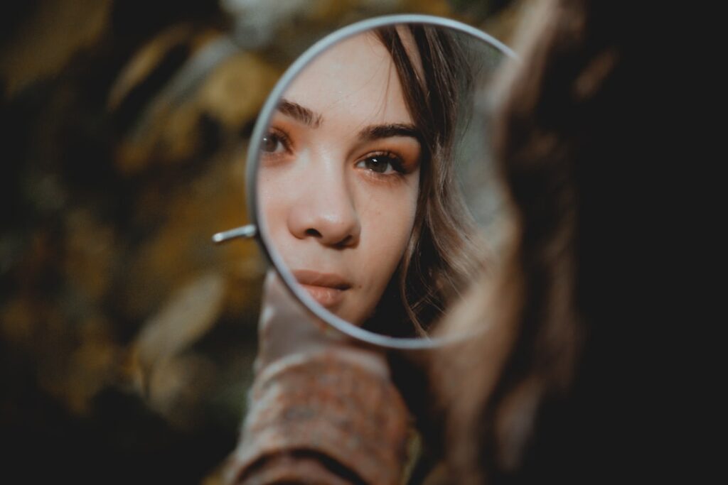 A concerned woman looking at her reflection emphasizing the need for caution and research before trying new beauty trend