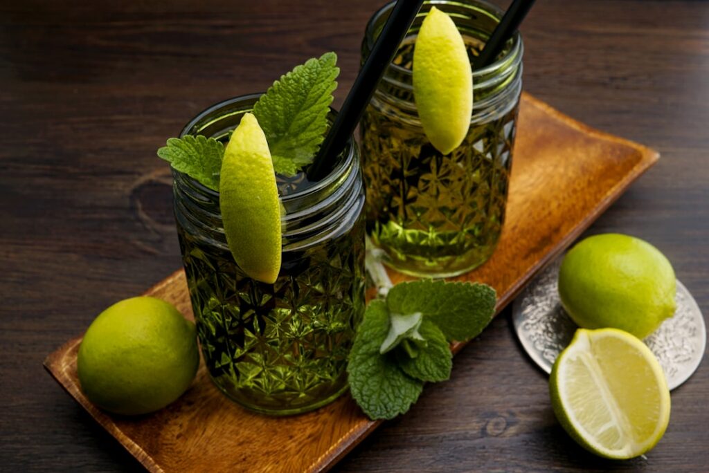 A clear glass with a refreshing chia seed and lime drink garnished with fresh lime slices and mint A small bowl of chia 