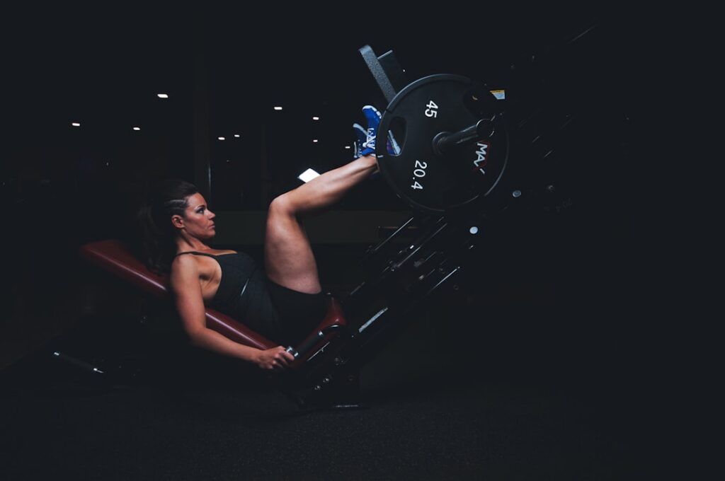 A person in a seated position with hands on the floor behind them extending legs out and then pulling knees into their c