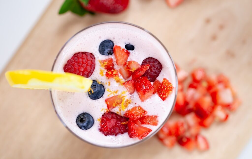 A clear glass filled with a visually appealing refreshing collagen drink showing small chia and flaxseeds settled or mix