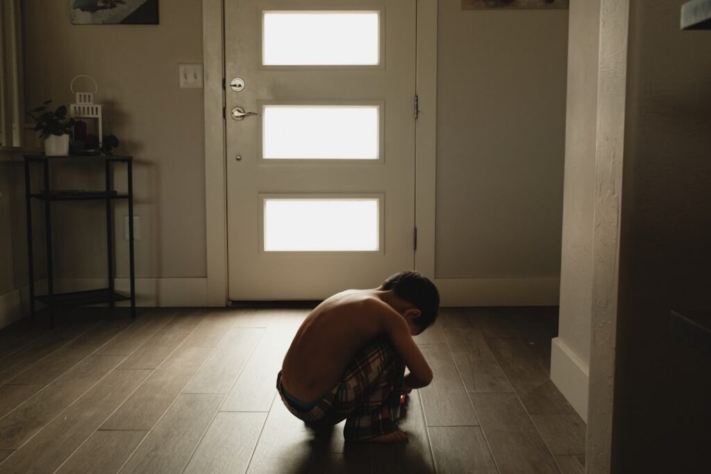 A person performing a bodyweight squat in a home setting demonstrating good form and a sense of effort