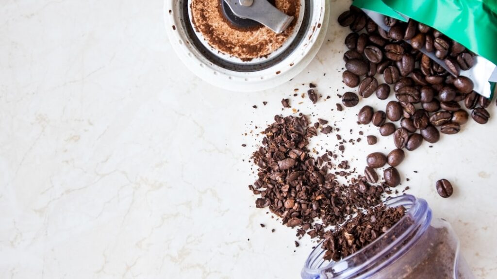A flat lay image showcasing various ingredients for DIY coffee face masks such as fresh coffee grounds a jar of honey a
