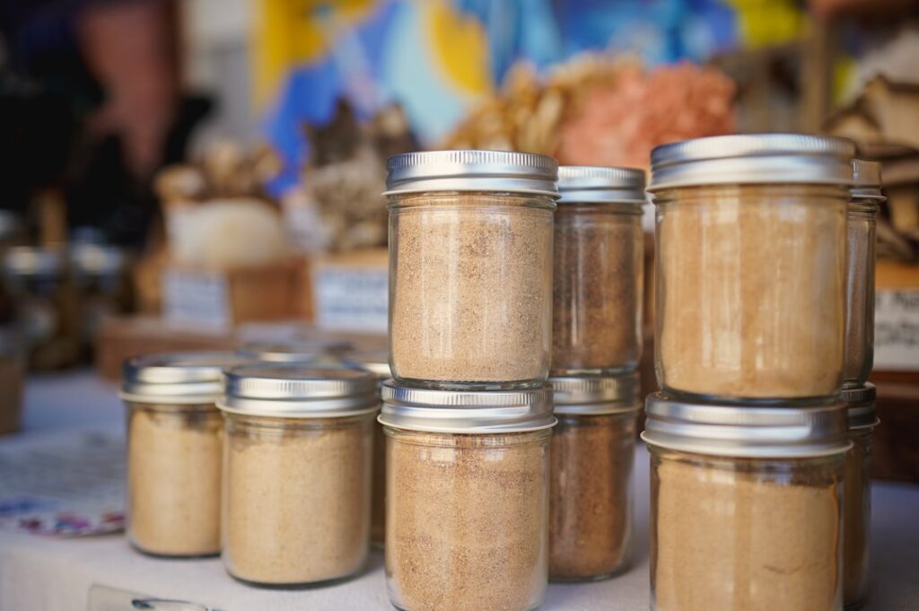 Three small elegant glass jars filled with different homemade aloe vera beauty products clearly labeled arranged neatly 