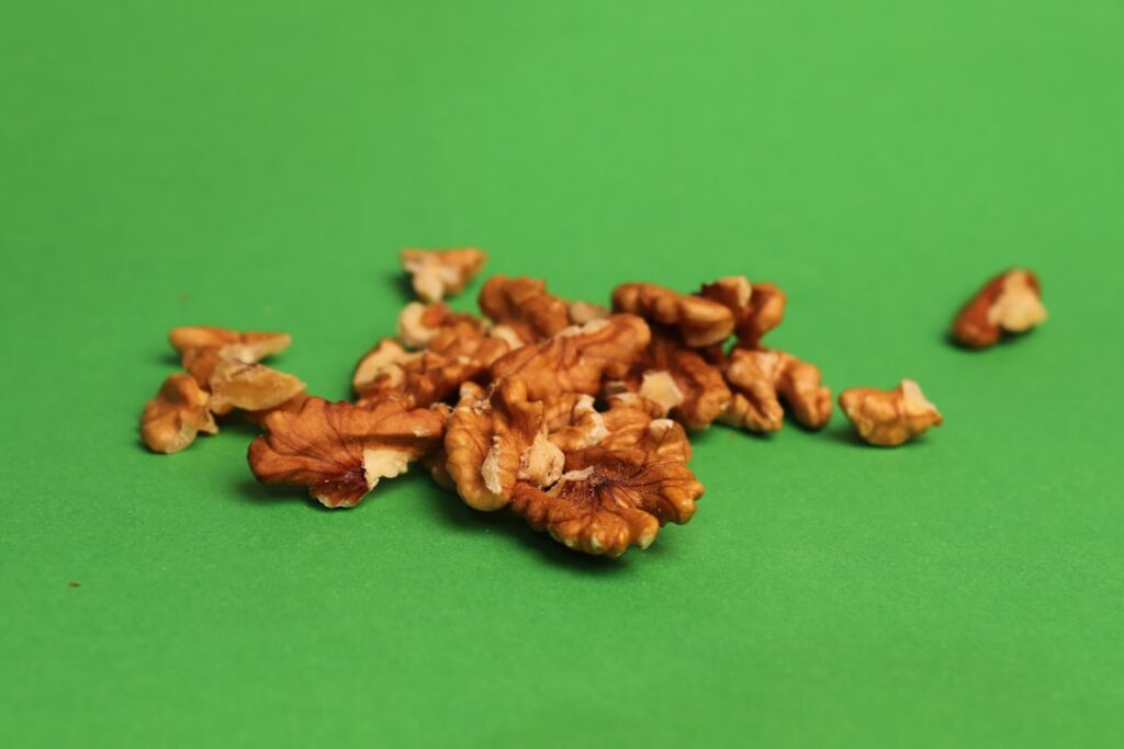 A small pile of about 5-6 pecan halves on a clean surface clearly showing a 100-calorie portion