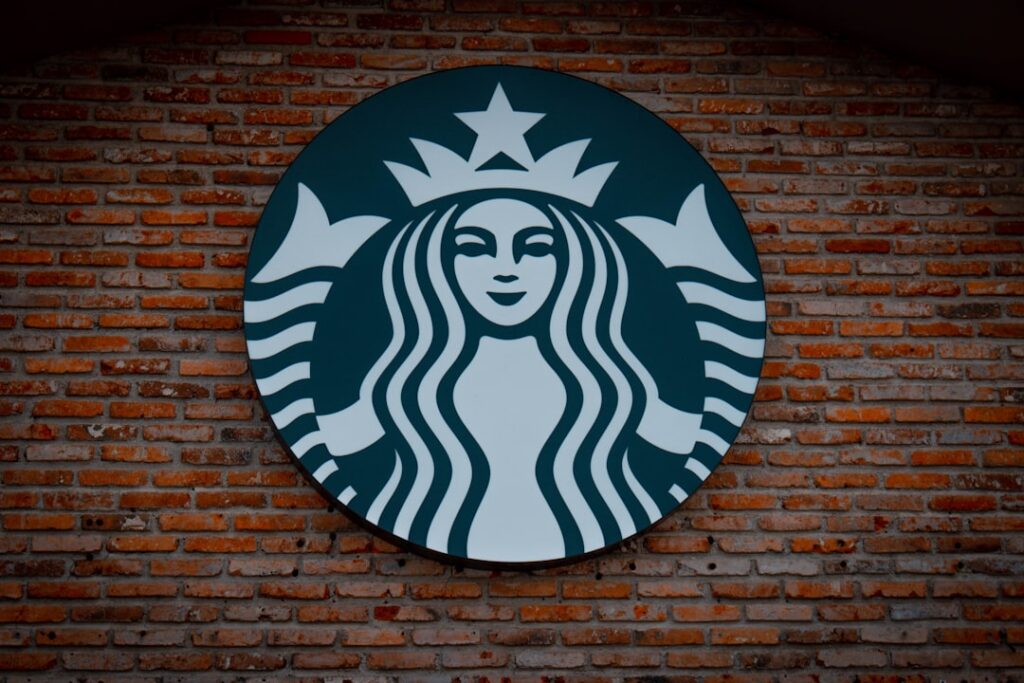 A collage of famous logos Nike swoosh Apple McDonald s golden arches Pepsi globe Starbucks siren each with one subtle co