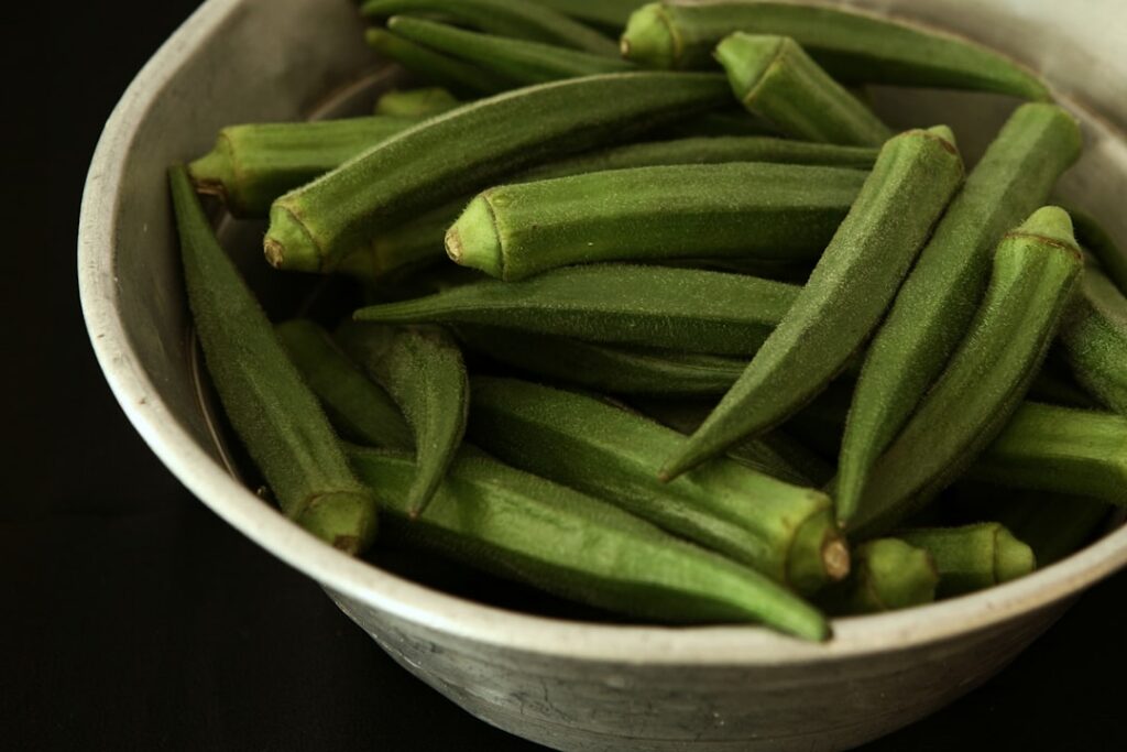 A refreshing glass of a light green slightly viscous drink possibly with a few sliced okra pieces or cloves as garnish s