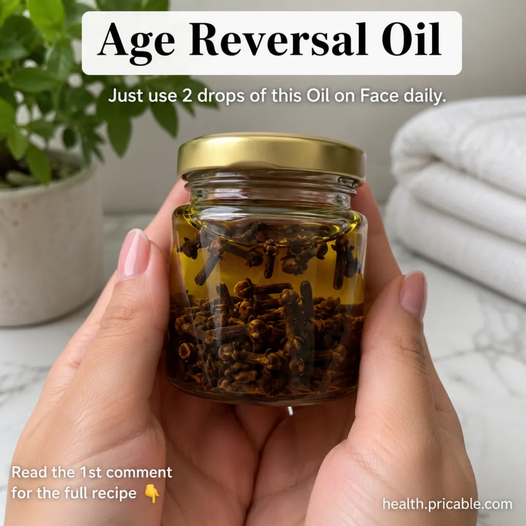 Hands holding a small glass jar of yellow oil with dried cloves suggesting a homemade age-reversal oil