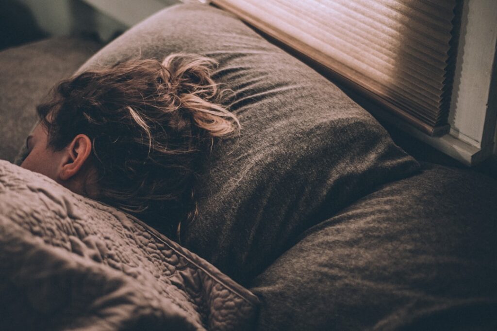 A person sleeping peacefully with a clock showing late evening and a light healthy meal on a bedside table suggesting av