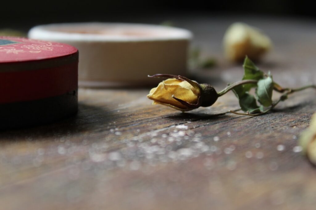 Various beauty powders and ground spices being mixed in a bowl with a spoon