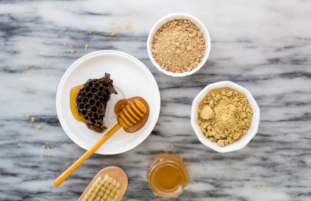 A bowl of fresh aloe vera gel and a spoonful of golden honey ready to be mixed for a face mask