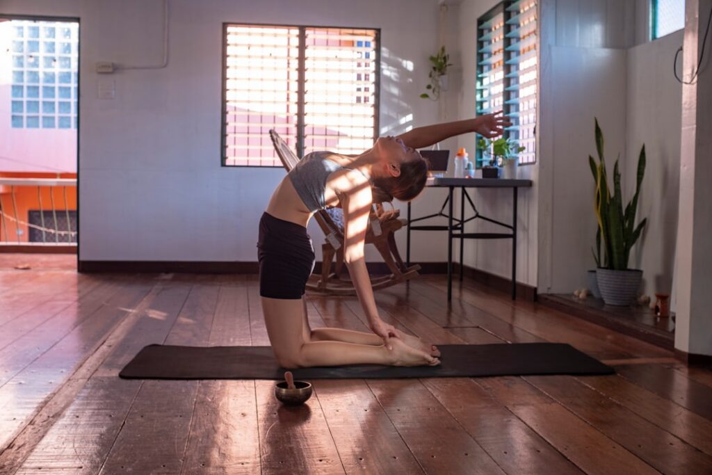 A person performing a standing twist exercise demonstrating proper form with hands clasped in front of the chest and twi