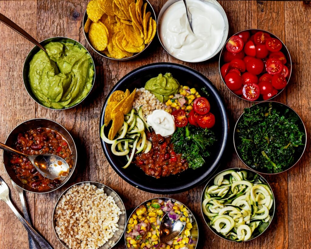 A vibrant spread of various easy vegan dishes including homemade banana oat cookies a slice of vegan banana bread a colo