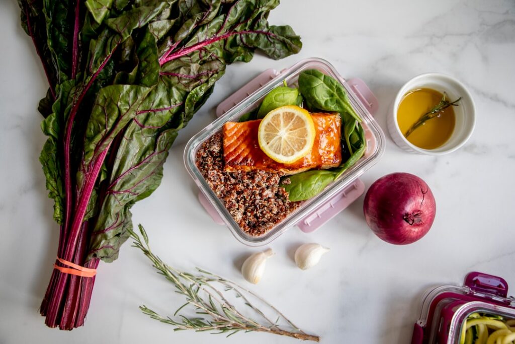 A vibrant balanced meal prep container filled with healthy food options like spinach salmon avocado and berries showcasi