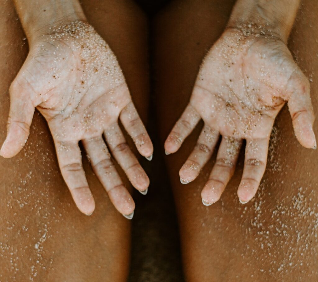 A woman gently scrubbing her knee with a homemade scrub