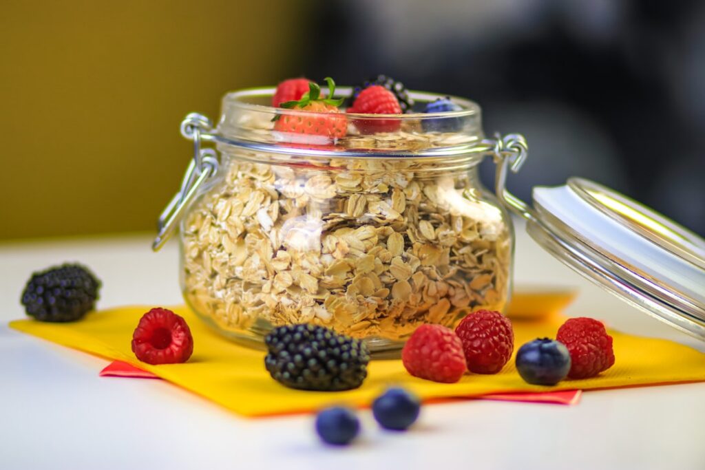 A close-up of a glass jar filled with vibrant overnight oats topped with fresh berries and nuts ready to be eaten The ba