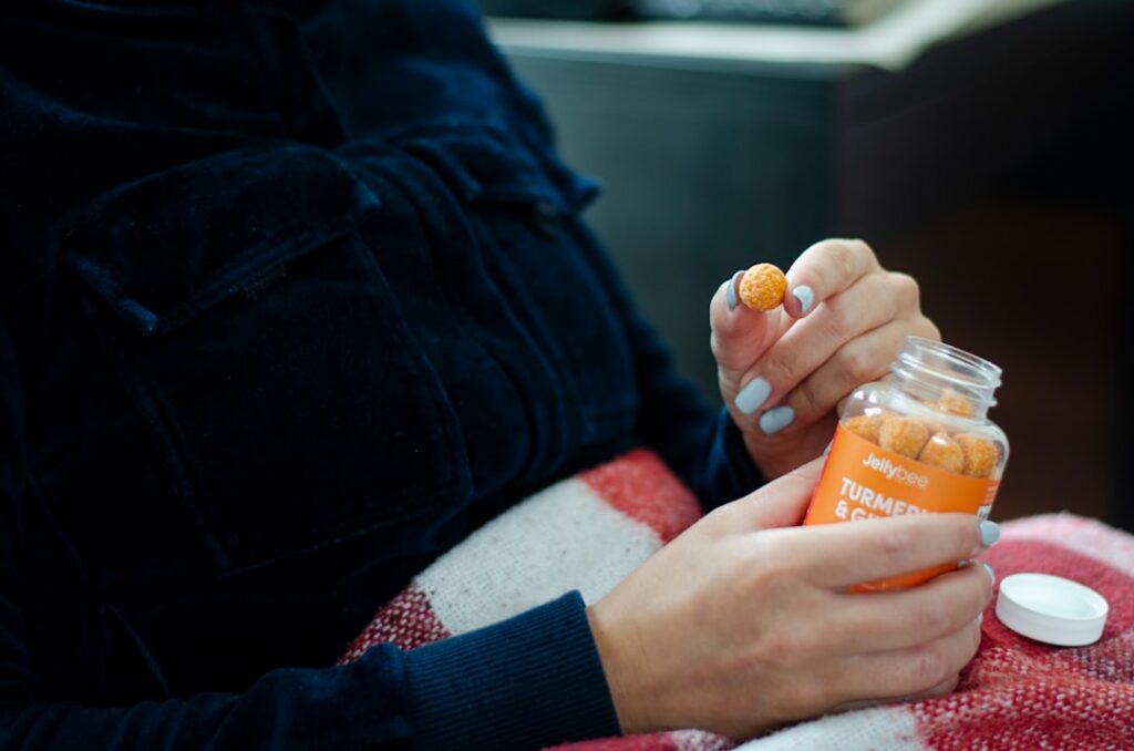 A woman applying a yellow face mask to her clean skin
