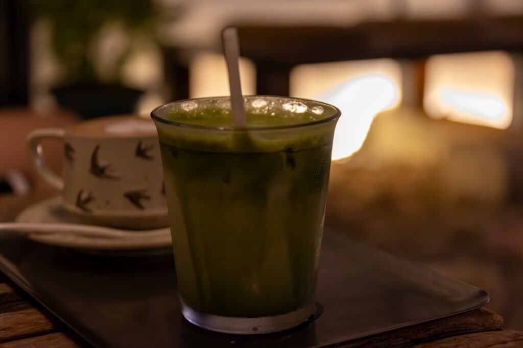 A refreshing and colorful matcha smoothie in a glass garnished with fresh berries and mint The image should convey vital