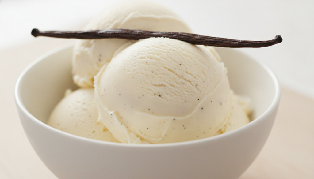A scoop of creamy vanilla ice cream in a white bowl garnished with a vanilla bean pod The texture is smooth and luscious
