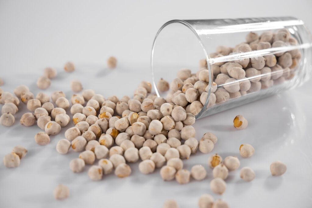 A visual comparison showing the quantity of hard-boiled eggs versus cooked chickpeas needed to achieve 30 grams of prote