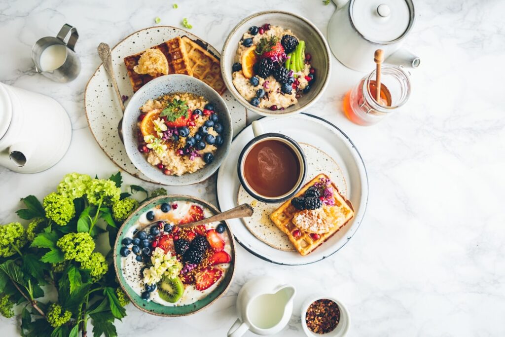A vibrant appealing spread of various high-protein breakfast options like scrambled eggs with spinach Greek yogurt with