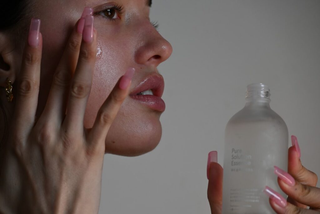 A hand gently applying a translucent okra gel to a person s cheek showing smooth glowing skin The gel looks light and re