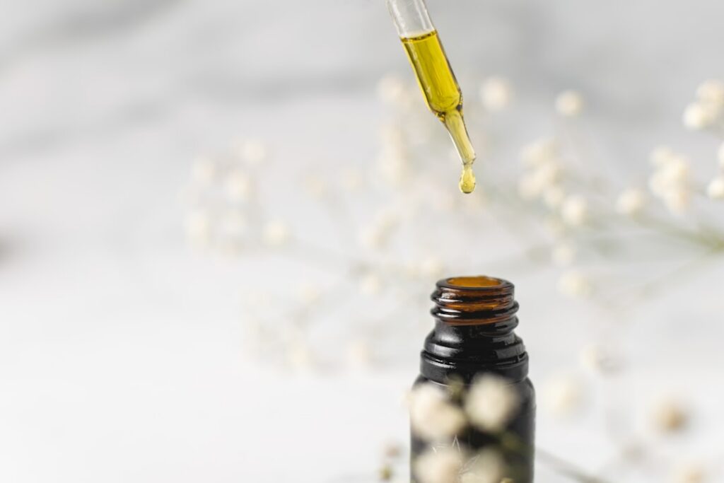 Various natural oils and ingredients for a DIY anti-aging serum arranged aesthetically with a small amber dropper bottle