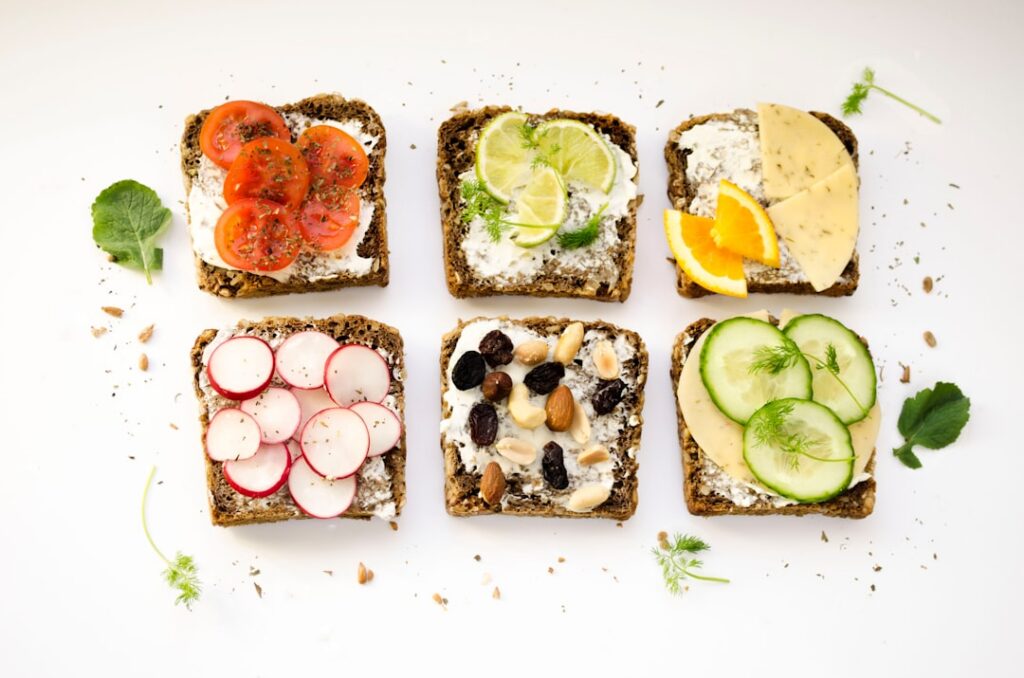 An overhead shot of various probiotic-rich foods artfully arranged on a wooden table including a bowl of plain yogurt wi