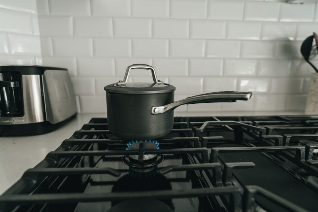 A pan on a stovetop with warm carrier oil and chopped onions simmering gently illustrating the oil preparation step