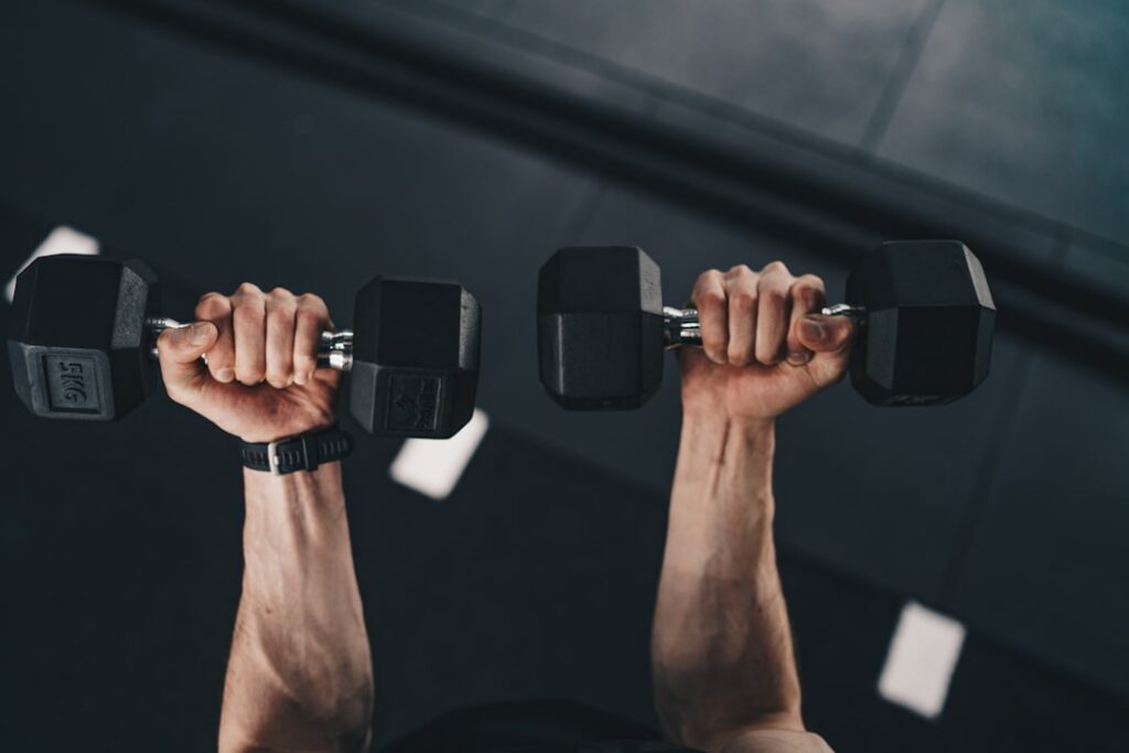 A person performing a dumbbell bench press with good form in a modern gym setting focusing on chest muscles