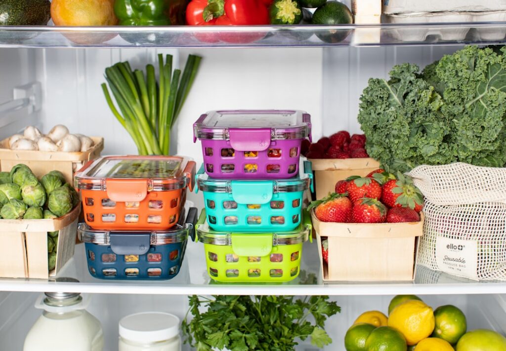 A well-organized refrigerator filled with various plant-based ingredients in clear airtight meal prep containers Include