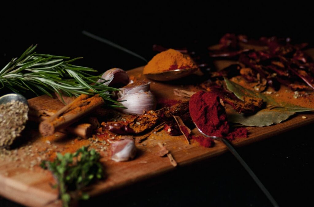 A collection of dried spices and nutritional yeast laid out on a clean surface ready to be blended into a vegan bouillon