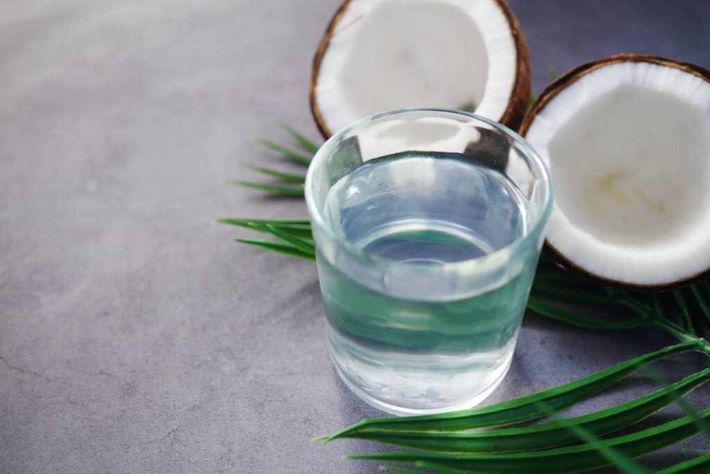 A visual comparison chart showing a glass of plain water next to a glass of coconut water with key nutritional facts lis