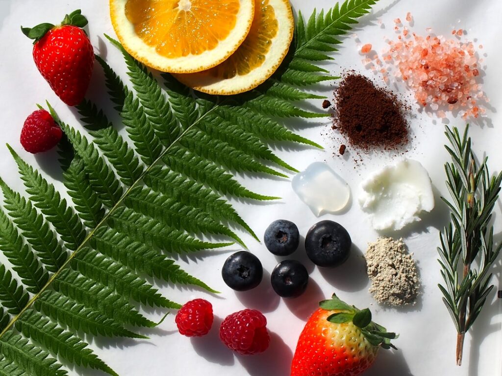 A flat lay of the DIY glass skin mask ingredients a small bottle of baby oil a jar of petroleum jelly a fresh aloe vera 