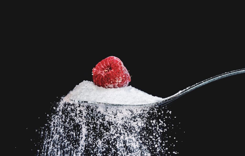 A person s hand holding a grocery item carefully reading the nutrition facts label focusing on the Sugars or Added Sugar